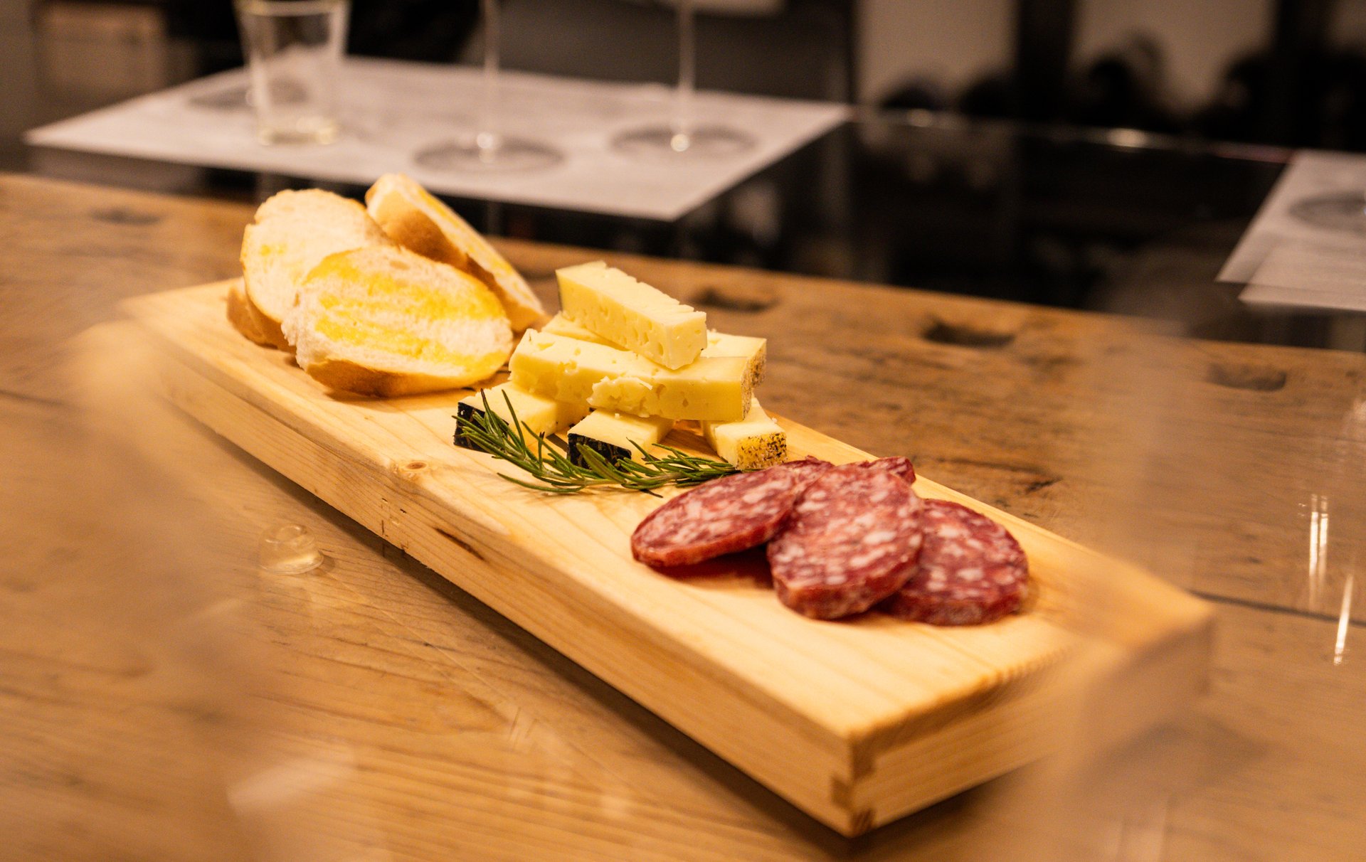 Tagliere di pane, formaggi di montagna e salame servito in cantina durante una degustazione Zanotelli